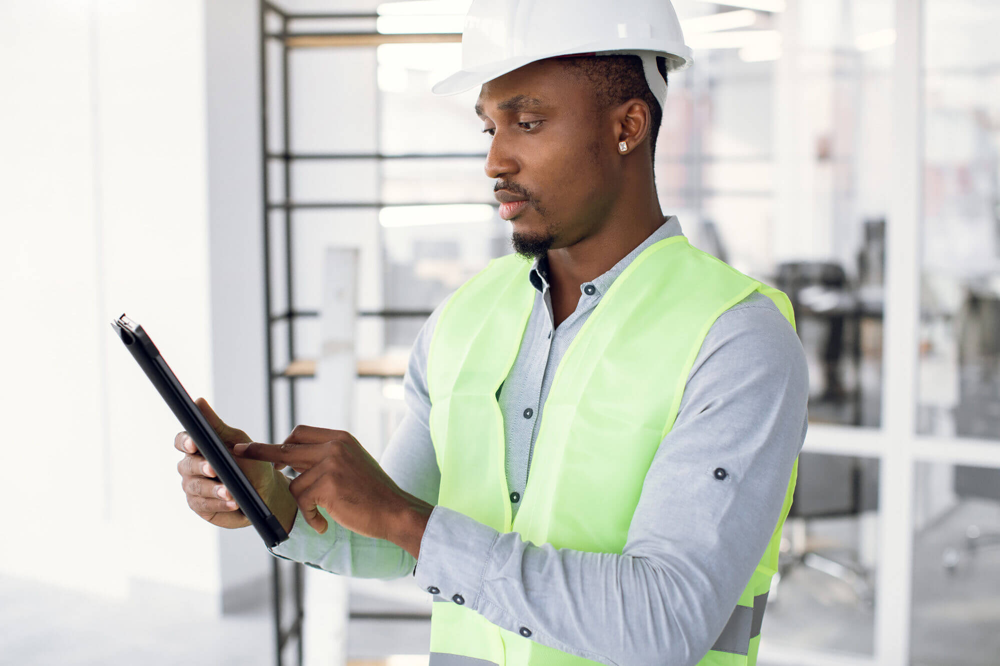 Inspector using digital tablet on construction object